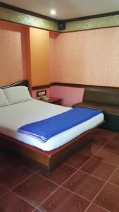 een slaapkamer met een groot bed met een blauwe deken bij West Wing Mansion in Bangkok