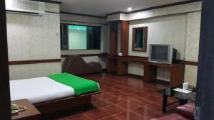 een hotelkamer met een bed en een televisie bij West Wing Mansion in Bangkok +15 foto's