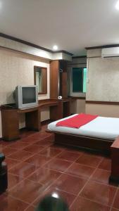 een slaapkamer met een bed en een tv erin bij West Wing Mansion in Bangkok