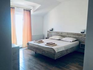 a bedroom with a large bed with two towels on it at Vila Alexia in Corbu