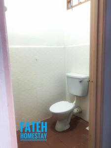 a bathroom with a white toilet in a room at Fateh Homestay in Arau