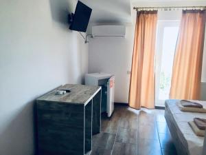 a small room with a bed and a desk in it at Vila Alexia in Corbu