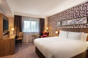 a hotel room with a large bed and a large window at Leonardo London Heathrow Airport in Hillingdon