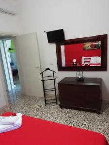 カザラーノにあるVilletta Doteの赤い敷物とドレッサーと鏡が備わる部屋