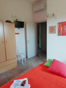 カザラーノにあるVilletta Doteの赤いベッドとキャビネット付きのベッドルーム1室が備わります。