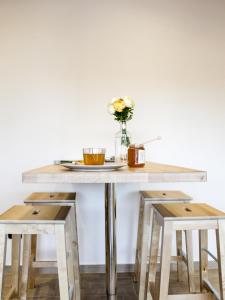 een tafel met twee krukken en een vaas met bloemen bij La Dimora apartments in Siculiana