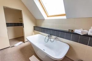 a bathroom with a white sink and a skylight at Great Hallingbury Manor in Bishops Stortford