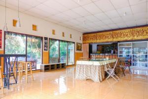 サラティガにあるRedDoorz near STAB Syailendra Kopengのテーブルと椅子、窓が備わる客室です。