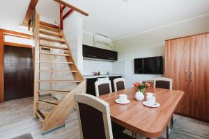 a kitchen and dining room with a wooden table and stairs at Apartamenty Gromada Międzyzdroje in Międzyzdroje