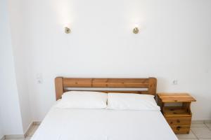 a bedroom with a bed and a wooden table at Afroditi Pansion in Agios Nikitas