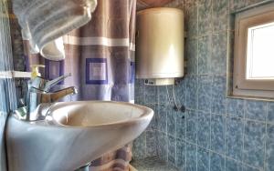 een badkamer met een wastafel en een raam bij Apartments Ribarić in Rab