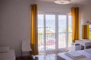 a room with a large window with yellow curtains at Hydas Pension in Selimiye