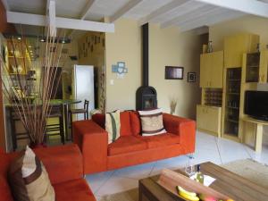 a living room with a red couch and a table at Beach Walk House and Cottage - Self Catering in Swakopmund