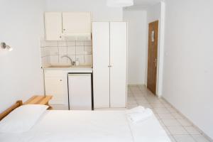 a kitchen with white cabinets and a sink in a room at Afroditi Pansion in Agios Nikitas