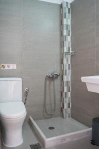 a bathroom with a shower with a toilet and a sink at Afroditi Pansion in Agios Nikitas