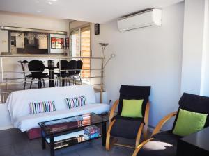 a living room with a couch and a table and chairs at Saromar II Apartament amb dues terrasses per 6 persones a 5 minuts de la Platja Gran in Platja  d'Aro
