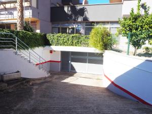 a building with a garage and stairs in front of it at Saromar II Apartament amb dues terrasses per 6 persones a 5 minuts de la Platja Gran in Platja  d'Aro