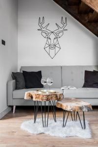 un soggiorno con tavolo e divano di Apartamenty ForRest Nowotarska a Zakopane