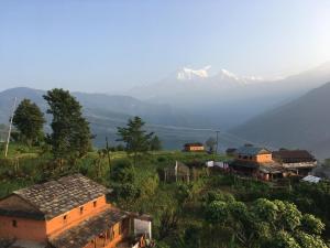 un groupe de maisons sur une colline avec une montagne dans l'établissement KB'S ECO MOUNTAIN VILLAGE HOME, à Kāskī