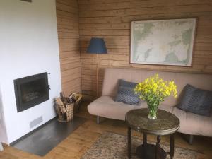 sala de estar con sofá y mesa con flores en Seaside cottage, en Kõiguste