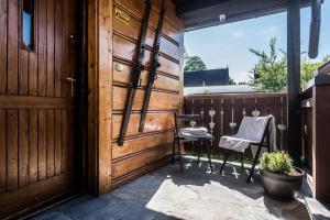 patio z 2 krzesłami i drewnianymi drzwiami w obiekcie Apartamenty ForRest Nowotarska w Zakopanem