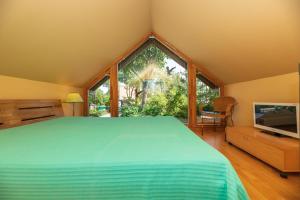 a bedroom with a large bed and a television at Vila PRI Rouzes in Palanga