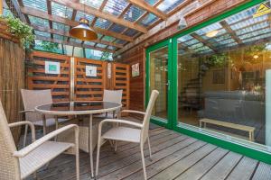 a patio with a table and chairs on a deck at Vila PRI Rouzes in Palanga