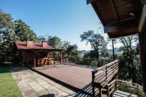 eine große Holzterrasse mit einem Pavillon im Hof in der Unterkunft Residencial Pousada Serrano in Gramado