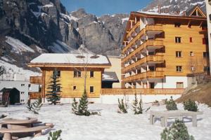 a large building in the snow with mountains in the background at Residenz Darianne 12 in Leukerbad