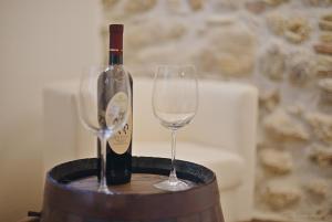 Una botella de vino y dos copas en un barril. en La Ruetta in pieno centro storico, en Ascoli Piceno