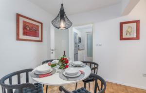 een eetkamer met een witte tafel en stoelen bij Apartment Biba in Poreč