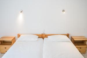 a bedroom with two beds and two night stands at Afroditi Pansion in Agios Nikitas
