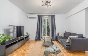 een woonkamer met een bank en een tv bij Apartment Biba in Poreč