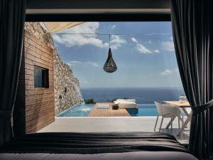 a bedroom with a view of a pool and a bed at Emerald Villas & Suites - The Finest Hotels Of The World in Agios Nikolaos