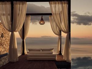 a living room with a couch in front of a window at Emerald Villas & Suites - The Finest Hotels Of The World in Agios Nikolaos