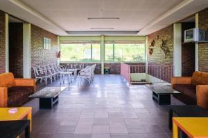 a restaurant with tables and chairs in a room at RedDoorz Syariah near Kopeng Treetop Adventure in Salatiga