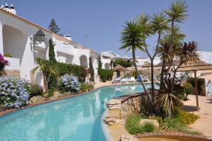 einen Pool in einem Resort mit Palmen in der Unterkunft Ocean Villas Luz in Luz