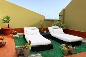 eine Terrasse mit zwei Sofas und Topfpflanzen in der Unterkunft Apartamentos Los Verodes in Frontera