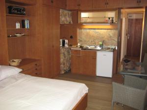 a bedroom with a bed and a kitchen with a sink at Ferienwohnung Kärnten Luise direkt am Ossiacher See in Villach