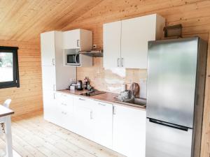 eine Küche mit weißen Schränken und einem Edelstahlkühlschrank in der Unterkunft W BAŃCE Glamping in Łódź