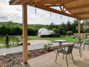 eine Terrasse mit Tisch und Stühlen auf einem Deck in der Unterkunft W BAŃCE Glamping in Łódź