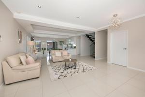 a living room with two couches and a table at Modern Luxury Ocean Views in Townsville