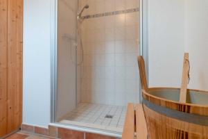 a bathroom with a shower with a wooden tub at Strandhaus Thiessow Whg_ 3 in Thiessow