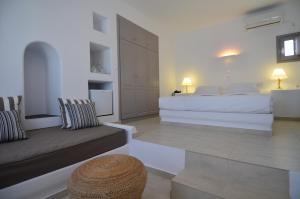 a white bedroom with a bed and a couch at Mar Inn Hotel in Chora Folegandros