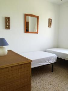 Les DevesesにあるMaite LOCDENIAのベッド2台と壁掛け鏡が備わる客室です。