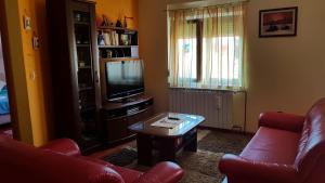 uma sala de estar com um sofá, uma televisão e uma mesa em NENA em Zadar