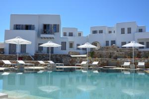 uma piscina com cadeiras e guarda-sóis e edifícios em Mar Inn Hotel em Chora Folegandros