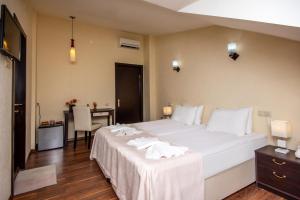 a bedroom with a large white bed and a desk at Lowell Hotel in Tbilisi City +51 photos