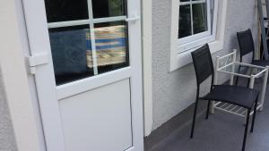 a door to a porch with two chairs and a table at Villa Signedal Hostel in Kvidinge