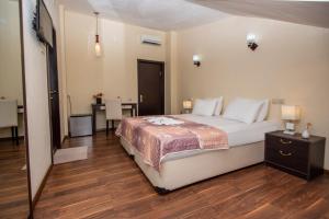 a bedroom with a large bed and a table at Lowell Hotel in Tbilisi City